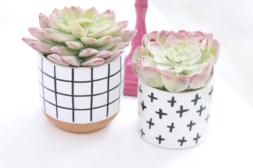 pink taper candle and modern black and white succulent table decor