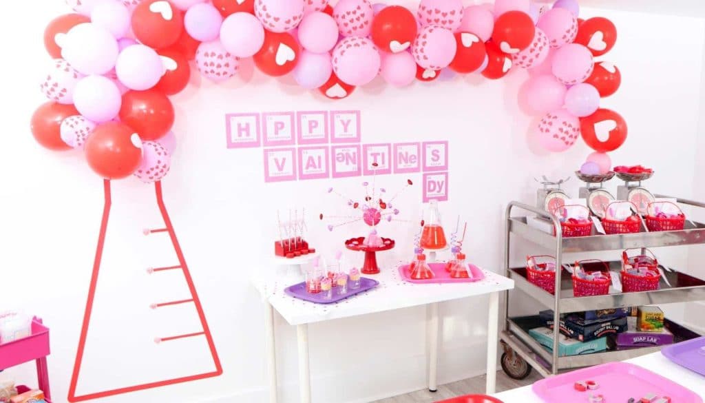 Create a "Laboratory of Love" DIY Backdrop for kids who love to learn this Valentine's Day! Get all of the details for a pink and red Valentine's Day Science Party for kids now at fernandmaple.com!