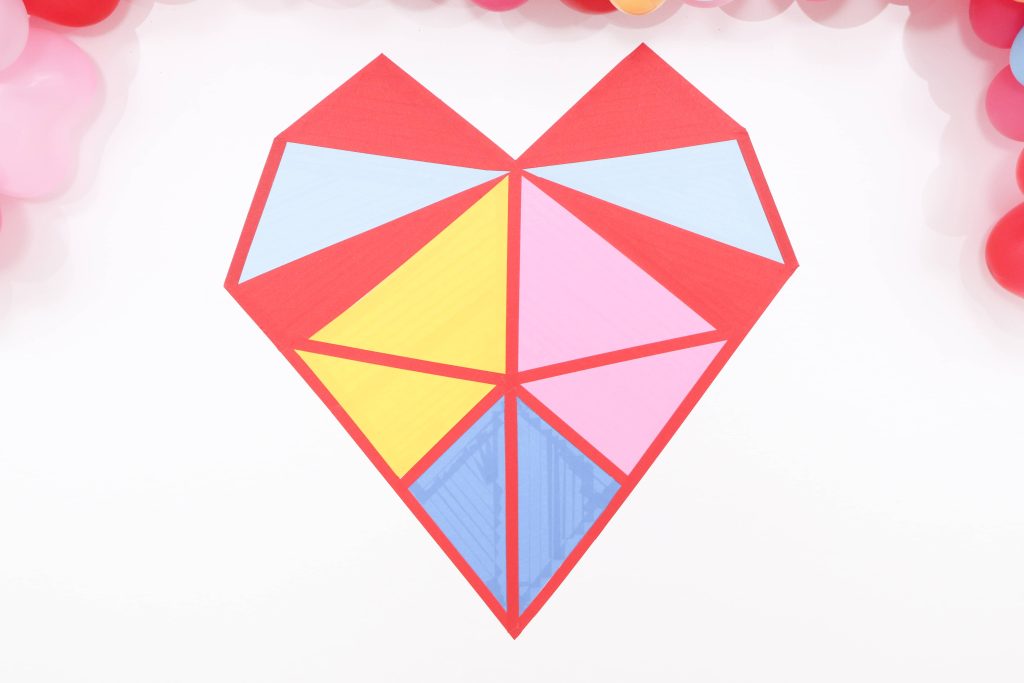 Colorful and modern Geometric Heart Valentine's Day Party DIY backdrop - Get details and more party ideas now at fernandmaple.com!