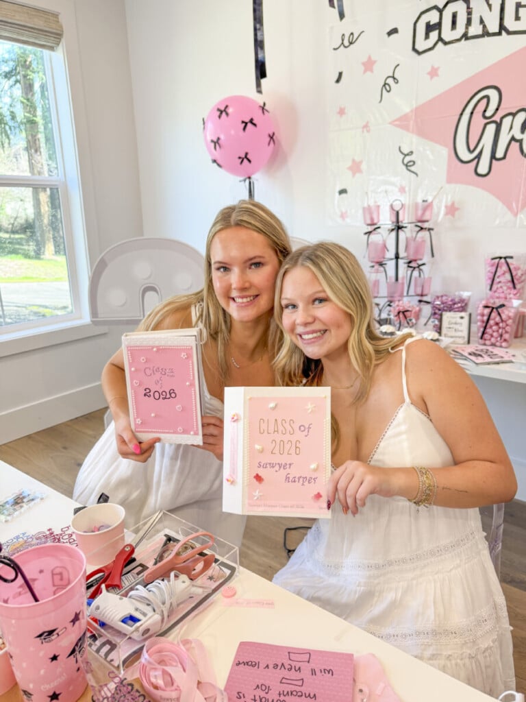 two girls holding personalized senior year memory boxes at graduation party