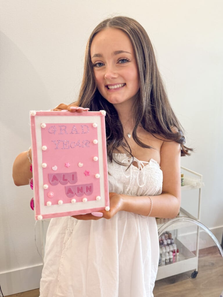 teen girls decorating senior year memory boxes at graduation party craft station