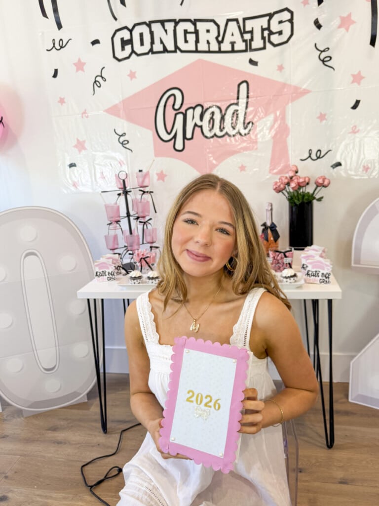 teen girls decorating senior year memory boxes with ribbon and card stock at graduation party craft station