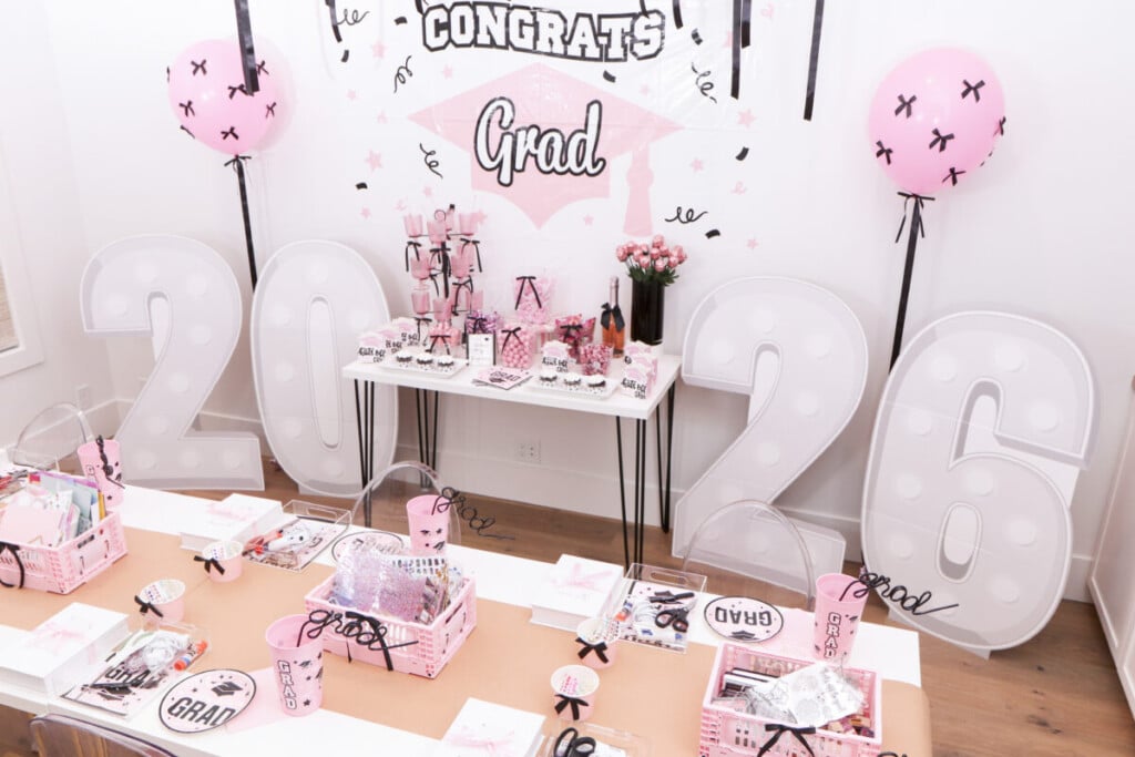 pink and black graduation party setup with balloon and bows backdrop, candy bar and 2026