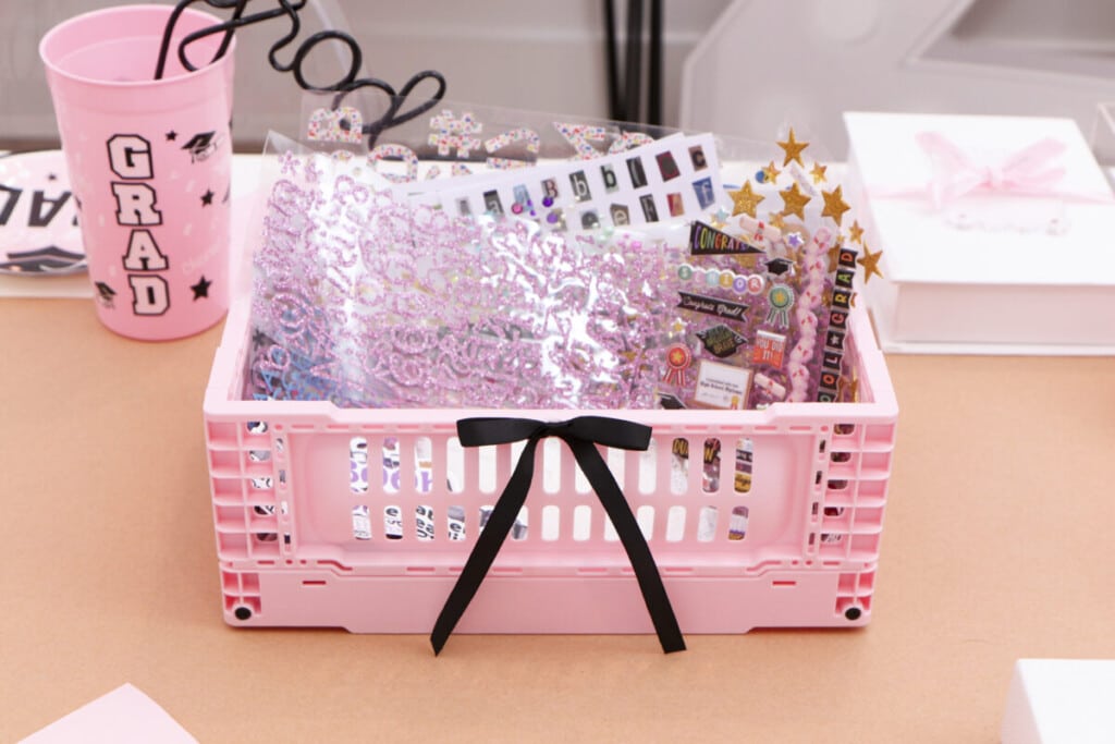 pink crates filled with stickers for graduation party craft station