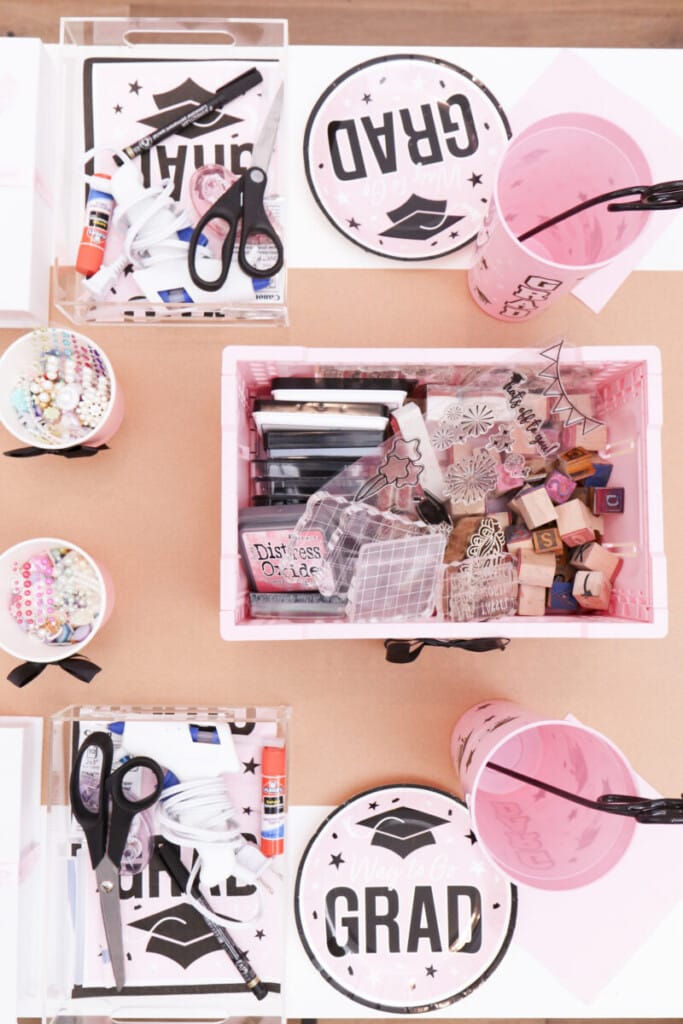 overhead view of graduation craft station place settings with pink lined acrylic trays