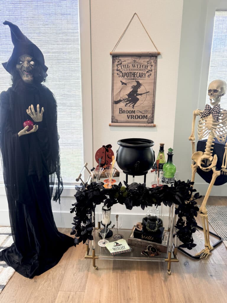 witch party potion bar with cauldron drink dispenser, bar cart and animatronic witch and skeleton