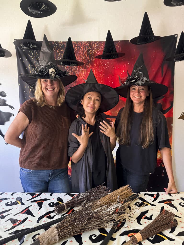 withces at a witch party broom making station with dancing witches backdrop