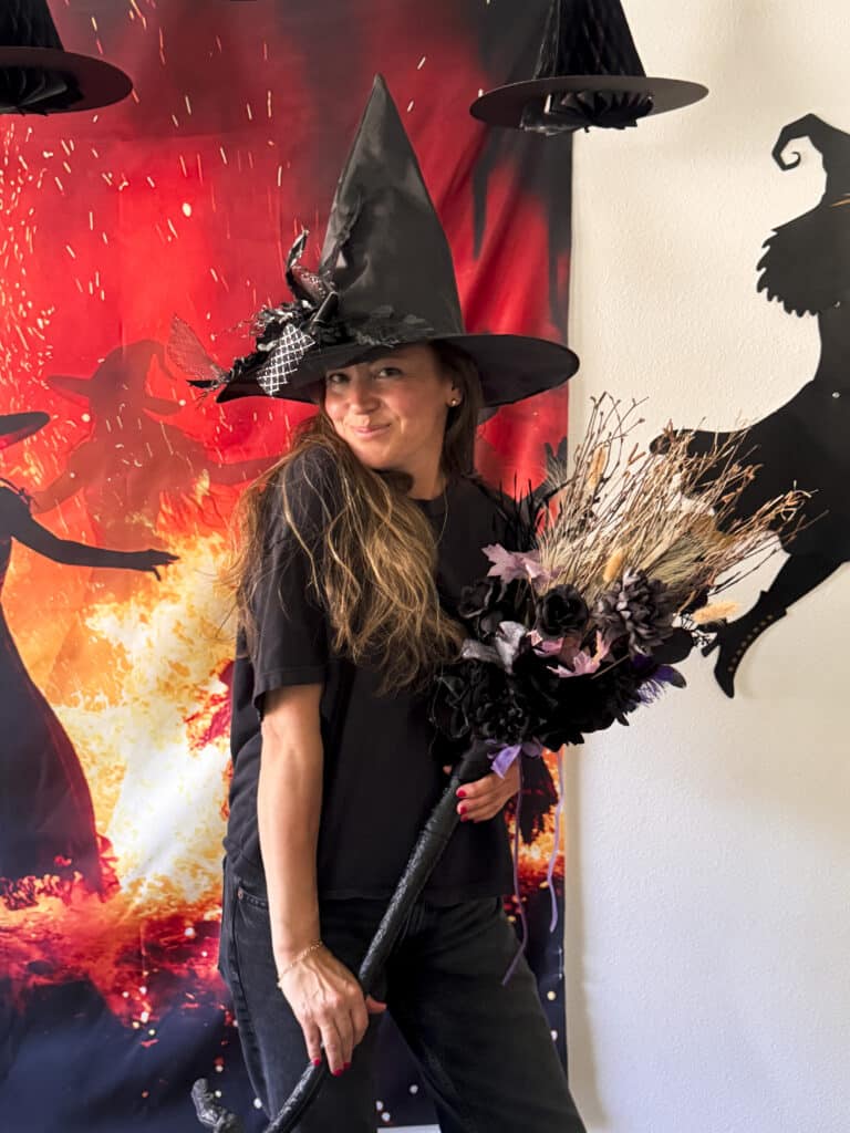 witch with handmade decorated witch broom made at a broom decorating witch party