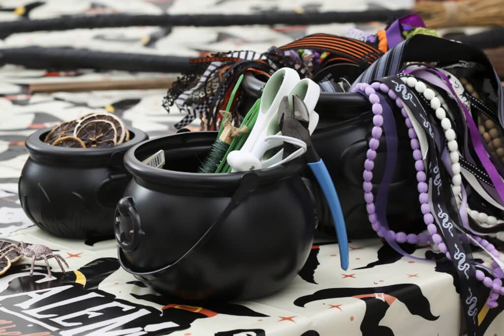 cauldrons filled with broom decorating supplies