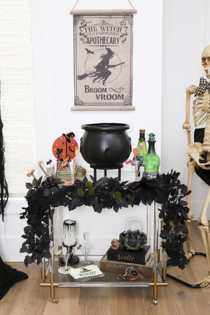 Practical Magic party ideas — witch party potion bar with cauldron drink dispenser, bar cart and animatronic witch and skeleton