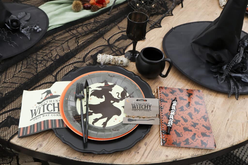 witch party table setting with witch plates, black cauldron mug and personal witch hats