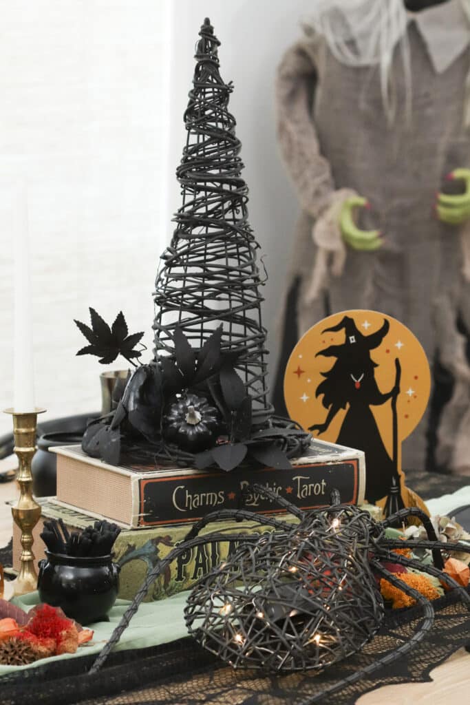 witch party table centerpiece decorated witch hat, spider and spell book centrepiece