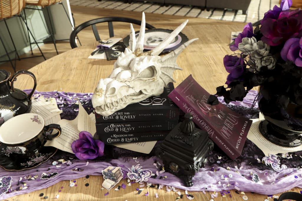 Dark romantasy book club themed dragon centerpiece and table runner with purple florals